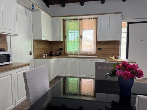 a kitchen with a vase of flowers on a table at Raffaello's Villa in Vlorë