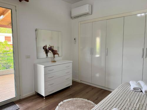 a white bedroom with a dresser and a closet at Raffaello's Villa in Vlorë