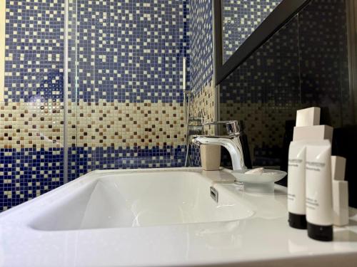 a bathroom with a white sink and blue tiles at Raffaello's Villa in Vlorë