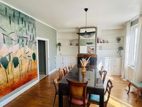 une salle à manger avec une table, des chaises et un grand tableau dans l'établissement Beautiful Champagne house, à Hauteville