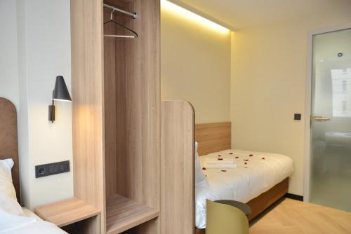 a small room with a bed and a mirror at Day8 Hotel in Cologne