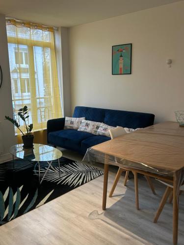 un salon avec un canapé bleu et une table dans l'établissement Poppy-Ideally located, Next station,Gd Palais&City, à Lille
