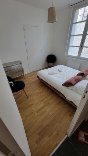 une chambre avec un lit et un parquet dans l'établissement T1 bis plein pied, à Saumur