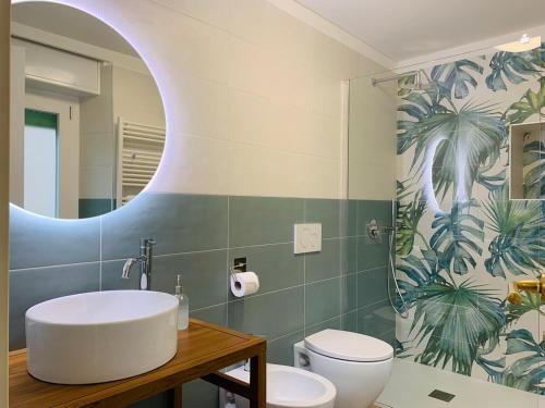 a bathroom with a sink and a toilet and a mirror at Ca' dal Pum - Lake Orta - Elegant holiday home in Gozzano