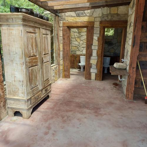 a bathroom with a large wooden cabinet and a toilet at Chale do guerreiro in Coroas