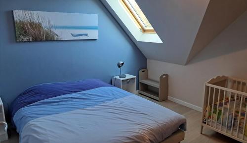 une chambre avec un lit et une lucarne dans l'établissement Maison au calme proche des plages du Golfe du Morbihan, à Baden