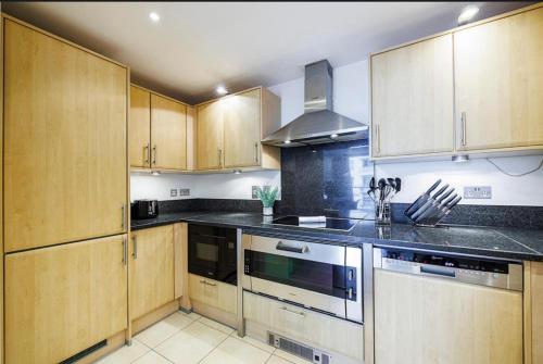 a kitchen with wooden cabinets and a stove top oven at Flat in CENTRAL LONDON for 4 in London