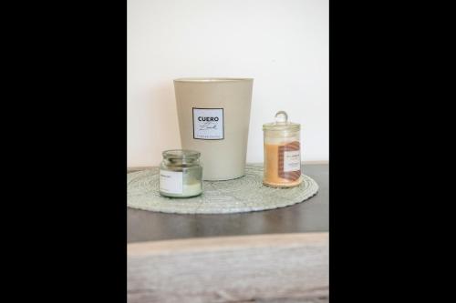 two candles sitting on a table with a bucket at L'Instant Versailles - Proche Golf & Centre in Guyancourt