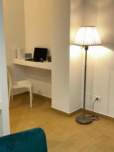 a room with a desk with a laptop and a lamp at Casa Riviera in Pescara
