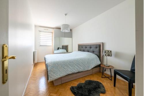 a bedroom with a bed and a chair at L'Instant Versailles - Proche Golf & Centre in Guyancourt