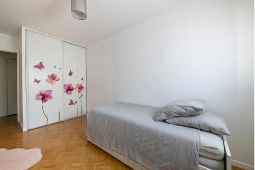 a bedroom with a bed with flowers on the wall at L'Instant Versailles - Proche Golf & Centre in Guyancourt