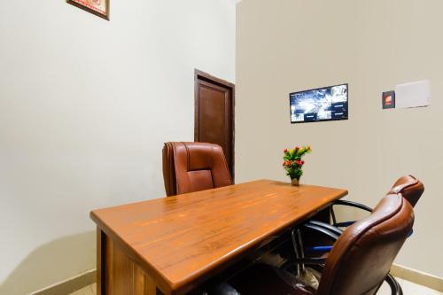 a wooden table and two chairs in a room at Hotel O Sabtera Homes in Kharar