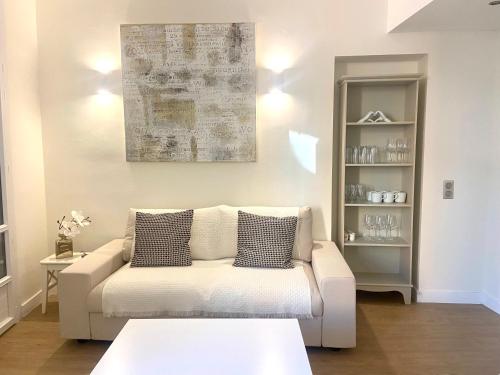 un salon avec un canapé blanc et une table dans l'établissement Elegant 2P Rue Meynadier 350 m Palais & beaches, à Cannes