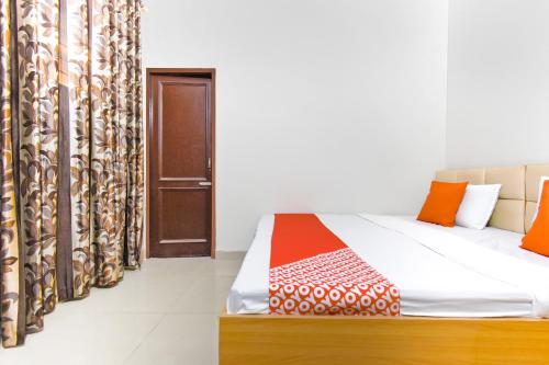 a room with a bed with an open door at Hotel O Sabtera Homes in Kharar