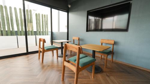 a waiting room with chairs and a table and a mirror at Rodona Hotel in Mexico City
