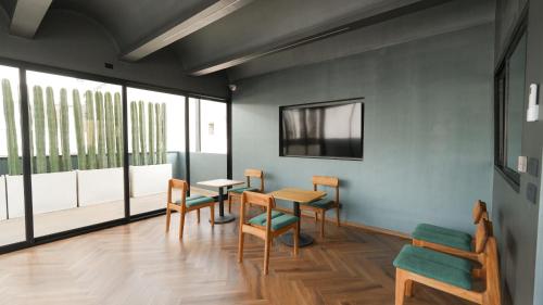 a room with a table and chairs and windows at Rodona Hotel in Mexico City