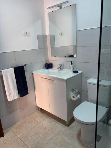 a bathroom with a sink and a toilet and a mirror at Casa Caronehe in Fuencaliente de la Palma