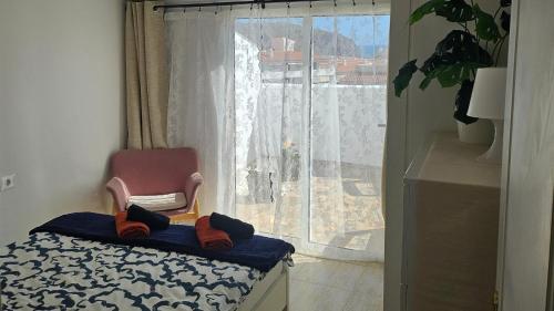 a room with a chair in front of a window at Los Cristianos Penthouse in Arona