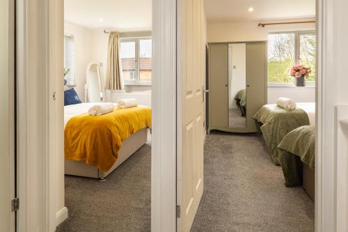 a bedroom with a bed with a yellow blanket at The Little Chinoiserie 2 bed house with large garden and only 7 min away from MK Central Rail station and City Centre in Milton Keynes