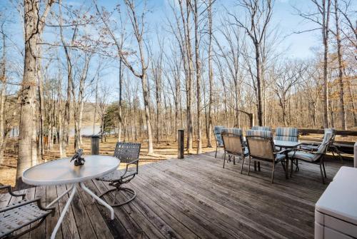 Una terraza de madera con una mesa y sillas. en Lakefront w Water Toys Deck Fire Pit & Grill, en Springfield