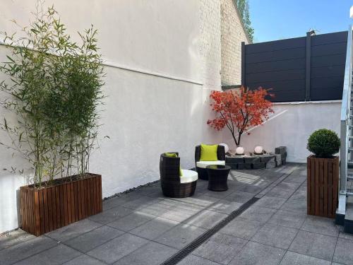 a patio with chairs and plants in front of a building at Day8 Hotel in Cologne