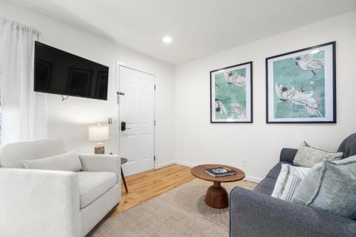a white living room with a couch and a table at Swell House Santa Cruz in Santa Cruz