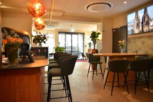 a bar in a restaurant with chairs and a table at Day8 Hotel in Cologne