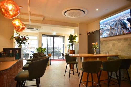 a restaurant with a table and chairs and a large screen at Day8 Hotel in Cologne