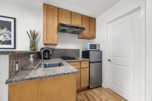 a kitchen with a sink and a refrigerator at Swell House Santa Cruz in Santa Cruz