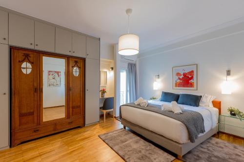 a bedroom with a large bed with blue pillows at Mia Homes - Acropolis in Athens