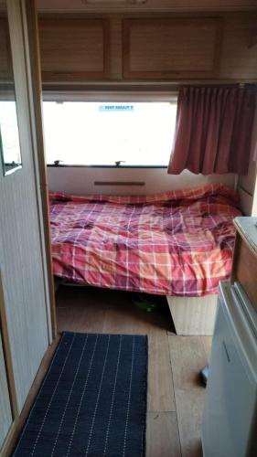 a small bed in a room with a window at Caravana em Quinta das Lameiras in Tomar