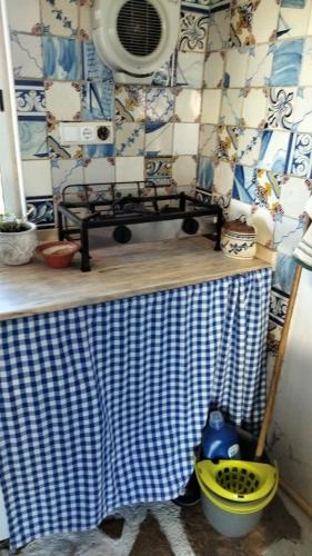 a kitchen with a table with a blue and white tiled wall at Caravana em Quinta das Lameiras in Tomar