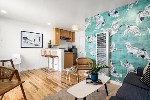 a living room and a kitchen with white birds on the wall at Swell House Santa Cruz in Santa Cruz