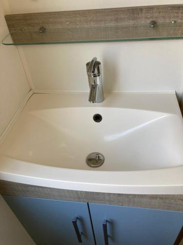 un évier blanc avec un robinet en argent dans l'établissement Chez Maxime - E33 - Clim TV Lave-vaisselle - Proche Europa Park et Rulantica, à Boofzheim