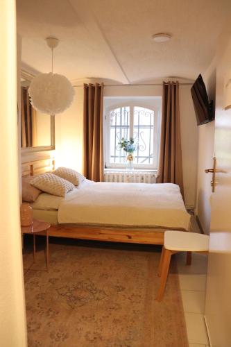 a bedroom with a large bed and a window at Hostel Bertha-Marie Vanilletraum in Greifswald