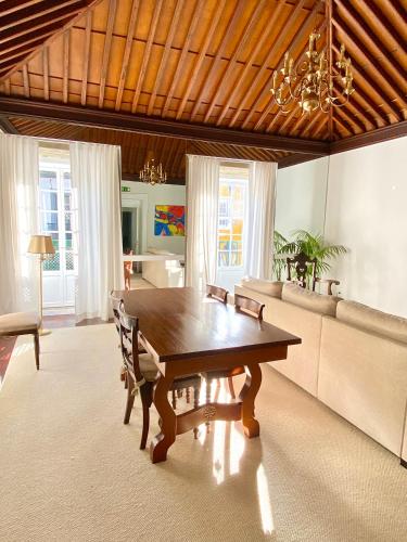 a living room with a wooden table and a couch at CASA de FORO - Apartamentos Turísticos in Angra do Heroísmo