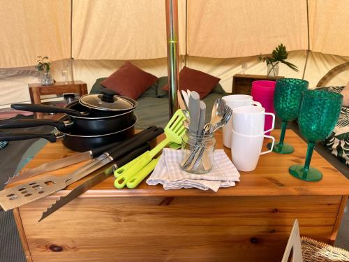 a wooden table with utensils on top of a tent at Readers Field Glamping in Great Sampford