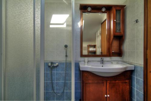 a bathroom with a sink and a shower with a mirror at Nefeles in Arachova