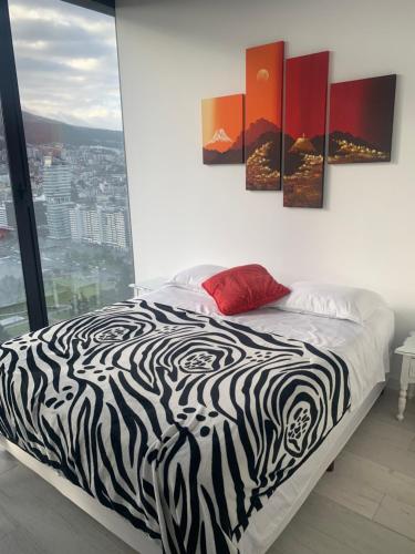 a bedroom with a zebra print bed with a view at B&B KELLY Ecuador in Quito
