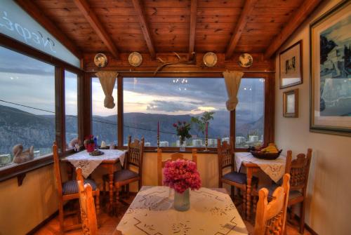 a dining room with tables and chairs and a large window at Nefeles in Arachova