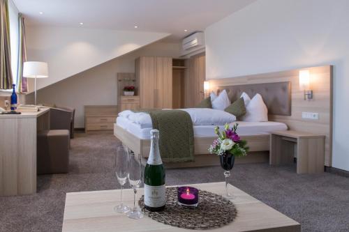 a hotel room with a bed and a bottle of wine at Hotel-Restaurant Birkenhof in Bad Soden-Salmünster