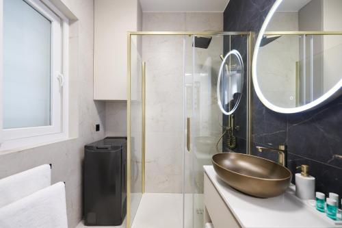 a bathroom with a bowl sink and a mirror at Platea Magna Lux Apartment in Zadar