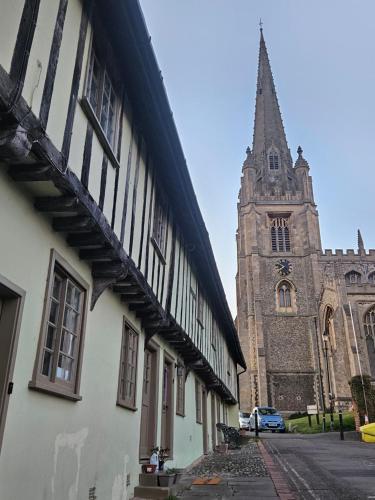 a church with a clock tower and a building at Readers Field Glamping in Great Sampford