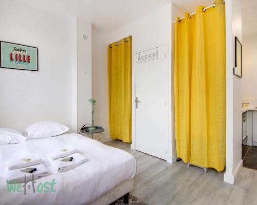 - une chambre avec deux rideaux jaunes et un lit dans l'établissement Lilly-Everything on foot,near stations,Gd Palais!, à Lille