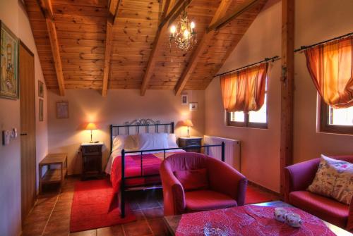 a bedroom with a bed and two chairs and a table at Nefeles in Arachova