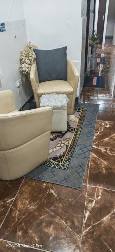 a living room with two couches on a tile floor at Abel homes in Abu Dhabi