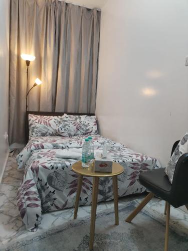 a bedroom with a bed and a table with a water bottle on it at Abel homes in Abu Dhabi