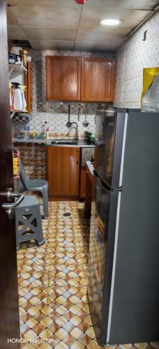 a kitchen with wooden cabinets and a refrigerator at Abel homes in Abu Dhabi