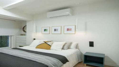a white bedroom with a bed and a window at Apartamento Balears Navarra Ibiza in Ibiza Town