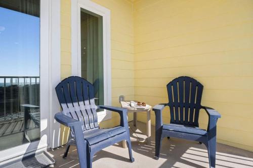 two blue chairs and a table on a porch at Grand Caribbean 2009 in Port Aransas